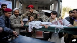 Pakistan army paramedic and rescue workers unload an injured victim of suicide bombing at hospital in Peshawar, Pakistan Dec. 25, 2010