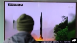 Seorang pria di sebuah stasiun kereta di Seoul, Korea Selatan, menonton berita di televisi mengenai peluncuran misil Korea Utara Kamis pagi (20/10).