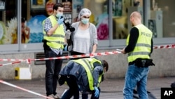 Des policiers ramassent les pièces à conviction trouvées au lieu de l’attentat au supermarché à Hambourg, Allemagne, 28 juillet 2017. 