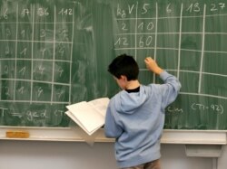 FILE: A student works on a math problem on the board, in preparation for the PISA test in 2004.