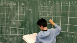 FILE: A student works on a math problem on the board, in preparation for the PISA test in 2004.
