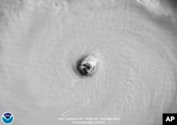 This satellite image provided by the National Oceanic and Atmospheric Administration (NOAA) shows the moment the eye of Super Typhoon Yutu passed directly over Tinian Island, one of three main islands of the U.S. Commonwealth of the Northern Mariana Islan