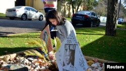 Un enfant place des messages de soutien pour l'ancien président Nelson Mandela devant sa maison de Johannesburg, 9 juin, 2013.