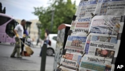 Newspapers are displayed in Athens, May 8, 2012. Europe's most indebted nation plunged into deep uncertainty after an election in which voters rejected mainstream pro-austerity parties.