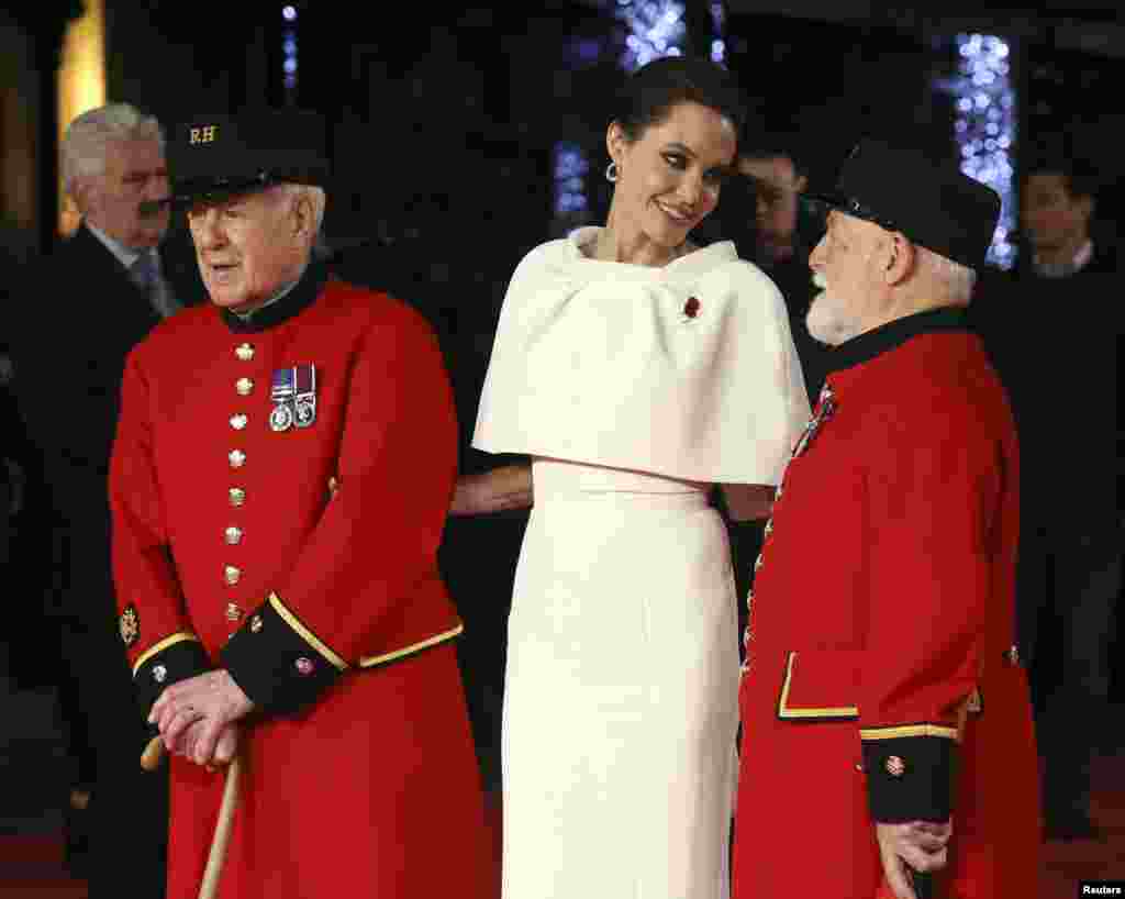 Angelina Jolie poses for a photograph with two Chelsea pensioners as she arrives for the UK premiere of &quot;Unbroken&quot; in central London, Nov. 25, 2014.