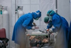 Petugas kesehatan merawat pasien COVID-19 di tenda darurat setelah 63 pasien meninggal dunia di RS Sardjito saat terjadi kelangkaan oksigen di Sleman, Yogyakarta, 4 Juli 2021. (Foto: Antara via Reuters)