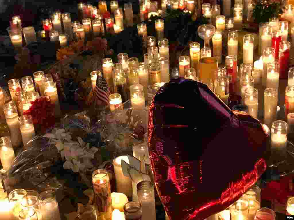Balon berbentuk hati dan berwarna merah mengawang di atas lilin-lilin yang menyala untuk menghormati para korban penembakan Las Vegas, 2 Oktober 2017. (Photo: S. Dizayee / VOA Turkish Service)