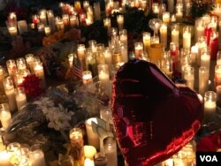 A red heart-shaped balloon flies over lit candles honoring the victims of the Las Vegas shooting, Oct. 2, 2017. (Photo: S. Dizayee / VOA Turkish Service)