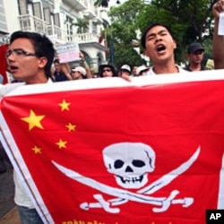 Vietnamese protesters hold a Chinese flag with a pirate sign during a protest in Hanoi, Vietnam, June 19, 2011