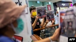 人们举着香港《苹果日报》为新闻自由而示威