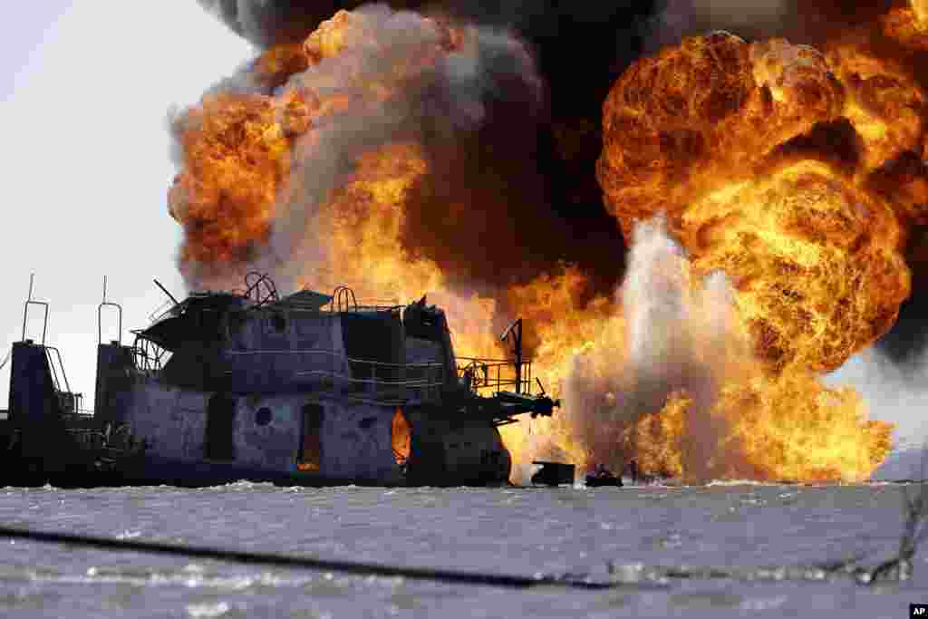 A fire still burns after a tugboat and barge hit a gas pipeline on March 12, 2013, in Perot Bay in Lafourche Parish, Louisiana, USA, about 30 miles south of New Orleans. 