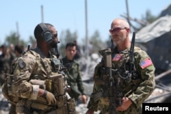 FILE - U.S. forces are seen at the Kurdish People's Protection Units (YPG) headquarters in Mount Karachok near Malikiya, Syria, April 25, 2017.