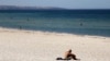 A beachgoer sits in the sun on Glenelg Beach in Adelaide, Australia, Jan. 24, 2019. 