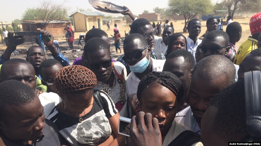 Les étudiants sur les cendres de leur restaurant brûlés par la police entonnant l'hymne national, à N'Djamena, Tchad, le 14 février 2017. (VOA/André Kodmadjingar)