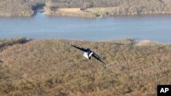 A military transport plane is seen below and on the starboard side from Air Force One while in flight from Palm Beach International Airport, Florida, to Andrews Air Force Base, Maryland, April 9, 2017.