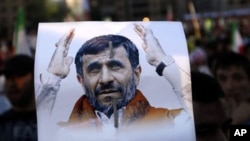 A Hezbollah supporter, holds a poster of Iranian President Mahmoud Ahmadinejad during a rally organized by Hezbollah for Ahmadinejad's visit to the southern suburb of Beirut, Lebanon, 13 Oct 2010