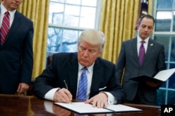 President Donald Trump signs the executive order withdrawing the U.S. from the TPP.