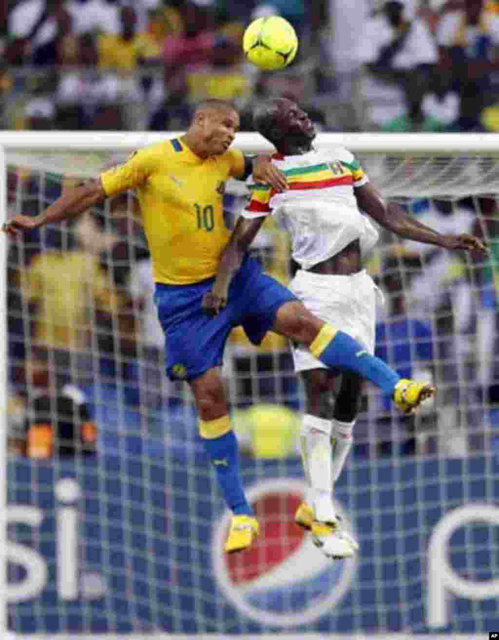 Gabon's captain Daniel Cousin (L) jumps for the ball with Mali's Drissa Diakite during their African Cup of Nations quarter-final soccer match against Mali at the Stade De L'Amitie Stadium in Gabon's capital Libreville February 5, 2012.