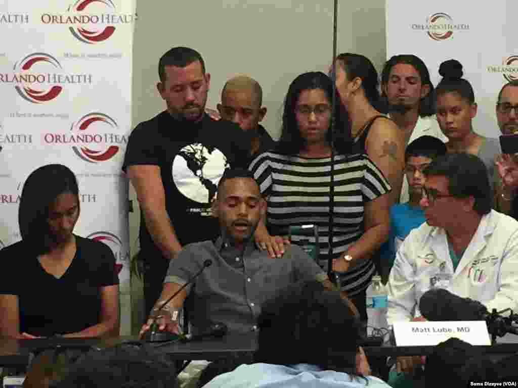 Angel Colon, a victim of the Pulse nightclub shooting, is comforted by family members as he speaks to reporters about the shooting Sunday, at a news conference at the Orlando Regional Medical Center, June 14, 2016.