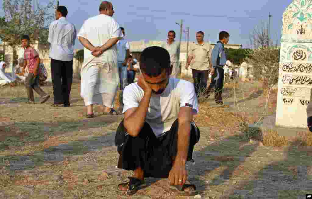 A Syrian man reacts after the funeral of 29 year-old Free Syrian Army fighter, Husain Al-Ali, who was killed during clashes in Aleppo, in the cemetery in town of Marea on the outskirts of Aleppo city, August 9, 2012.