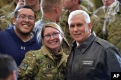 El vicepresidente de EE.UU. Mike Pence posa con soldados de su país durante una visita de Navidad a Afganistán.