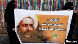 Pemrotes Syiah membawa poster Sheikh Nimr al-Nimr saat demonstran di luar Kedutaan Saudi di Sanaa (18/10).