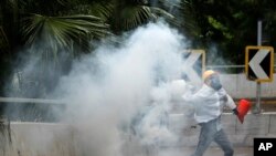 Un manifestante envía de vuelta a la policía una lata de gas lacrimógeno en Hong Kong, el domingo 6 de octubre de 2019. (AP Foto/Vincent Thian)