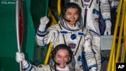 Astronot Jepang Koichi Wakata (tengah), kosmonot Rusia Mikhail Tyurin (membawa obor) dan Astronot AS Rick Mastracchio (atas, tidak terlihat) membawa obor Olimpiade dengan roket Soyuz-FG dari kosmodrome Baikonur, Kazakhstan, menuju ISS (7/11).