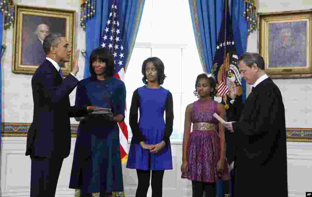 President Barack Obama is officially sworn-in by Chief Justice John Roberts in the Blue Room of the White House during the 57th Presidential Inauguration in Washington, D.C. Next to Obama are first lady Michelle Obama, holding the Robinson Family Bible, and daughters Malia and Sasha.