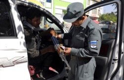 Afganistansko sigurnosno osoblje provjerava oružje na kontrolnom punktu oko Zelene zone, u kojem su ambasade, u Kabulu.