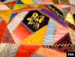 Quilt yang terbuat dari gabungan lembaran kain kecil yang tidak teratur yang disebut "crazy quilt." Quilt ini, yang dibuat oleh Mary Stinson, sekitar 1880. (J. Taboh/VOA)