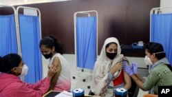 မွမ်ဘိုင်းမြို့မှာ ကိုဗစ်ကာကွယ်ဆေး ထိုးနှံပေးနေတဲ့ ကျန်းမာရေးဝန်ထမ်းများ။ (ဇန်နဝါရီ ၇၊ ၂၀၂၂)