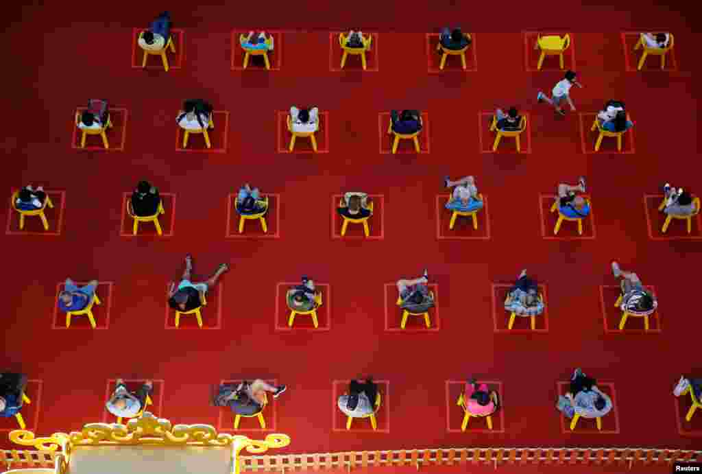 People watch an outdoor movie screening within their social distances during the COVID-19 outbreak in Singapore.