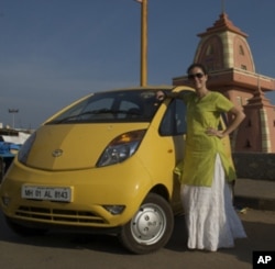 Blogger Vanessa Able stands beside her Tata Nano during her trip across India.