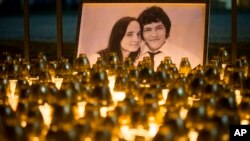 FILE - Light tributes are placed during a silent protest in memory of murdered journalist Jan Kuciak and his girlfriend, Martina Kusnirova, seen in the photograph, in Bratislava, Slovakia, Feb. 28, 2018. 