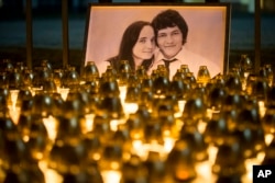 Light tributes are placed during a silent protest in memory of slain journalist Jan Kuciak and his girlfriend, Martina Kusnirova, seen in the photograph, in Bratislava, Slovakia, Feb. 28, 2018.
