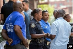 Police officers and their co-workers gather after a prayer service outside the 46th Precinct in the Bronx borough of New York, July 5, 2017.