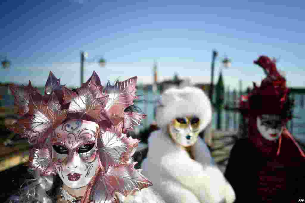 Revelers wearing masks and period costumes take part in the Venice Carnival in Venice, Italy, Feb. 23, 2019.