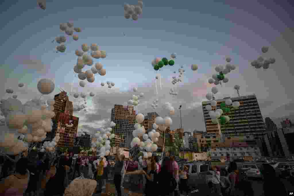People release scores of white balloons bearing the names of the Aug. 4 blast victims at about 6:07 p.m., when the deadly explosion occurred, to mark the two-month anniversary, next to the seaport of Beirut, Lebanon, Sunday, Oct. 4, 2020. (AP Photo/Hassan Ammar)