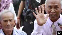 Khmer Rouge survivor Chum Mey, 81, right, talks to reporters as another survivor Bou Meng, 70, left, listens at Choeung Ek stupa, former Khmer Rouge killing field in the outskirt of Phnom Penh, file photo. 