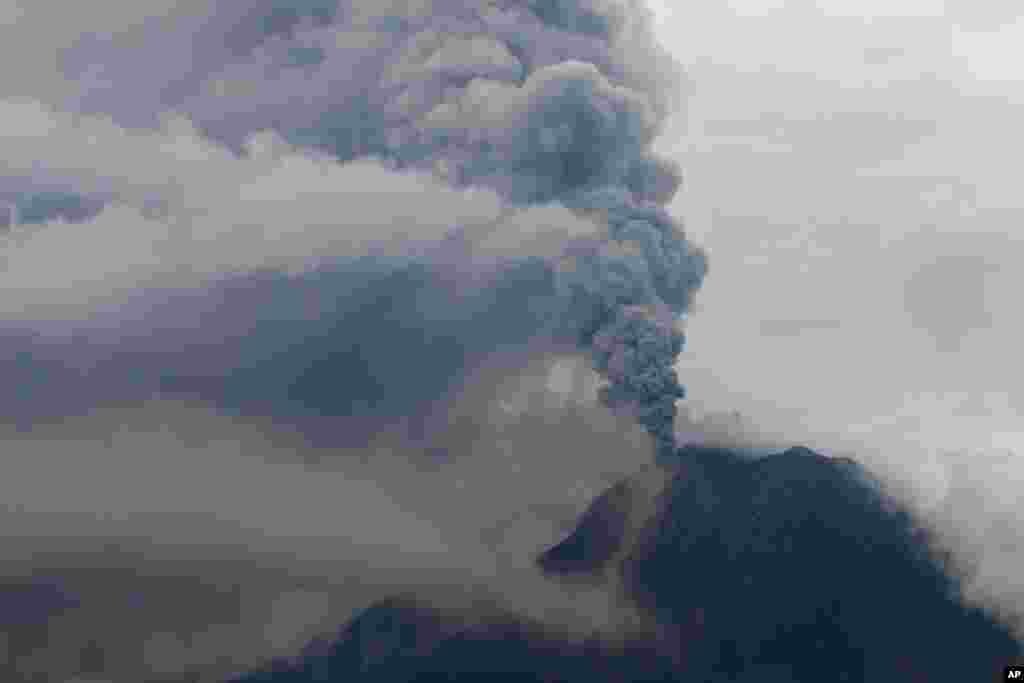 Mount Sinabung spews volcanic ash as it erupts as seen from Simpang Empat, North Sumatra, Indonesia.