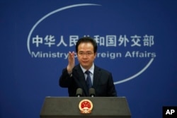 FILE - China's Foreign Ministry spokesman Hong Lei gestures during a daily briefing at the Ministry of Foreign Affairs office in Beijing, April 5, 2016.