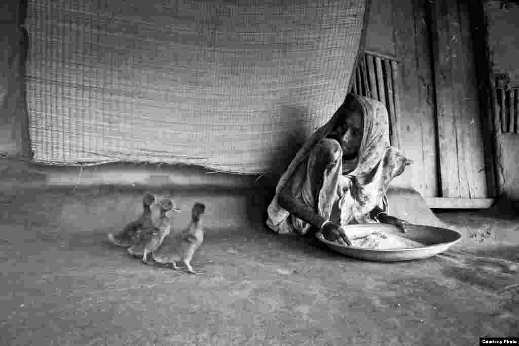 Juara pertama diraih Raihan Parvez dari Bangladesh dengan foto berjudul &quot;Existence&quot;. Berlokasi di Gabura, Bangladesh, foto ini menggambarkan seorang perempuan, barangkali berusia sekitar 90 tahun, sedang membersihkan beras, sementara tiga ekor itik di dekatnya menunggu si nenek berpaling agar bisa mengambil beras.