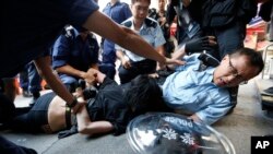 Nhân viên cảnh sát đội mũ sắt và mang khiên xông vào đám đông người biểu tình tại các rào cản ở khu Mong Kok