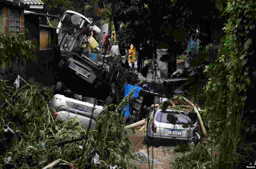 People try to recover belongings at a damaged area in Realengo neighborhood after heavy rains in Rio de Janeiro, Brazil.