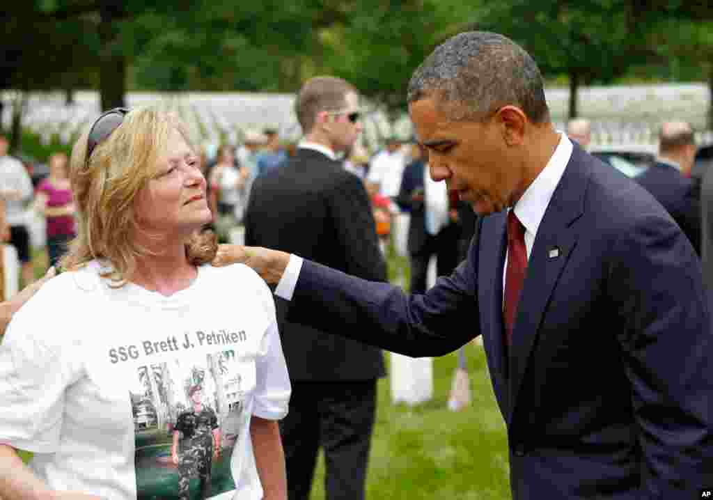 President Barack Obama speaks to a visitor at Arlington National Cemetery in Arlington, Virginia.