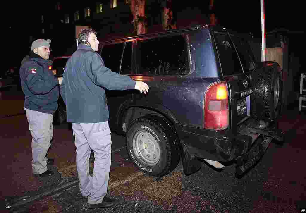 Lebanese private security men, left, escort a Lebanese police vehicle carrying one of two injured French journalists wounded by Syrian government shelling to a Lebanese hospital. (AP)