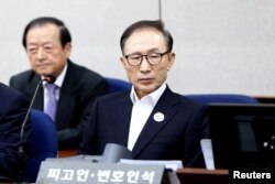 FILE - Former South Korean President Lee Myung-Bak appears for his first trial at the Seoul Central District Court, May 23, 2018, in Seoul, South Korea.