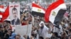 Supporters of Muslim brotherhood's presidential candidate Mohamed Morsi wave Egypt's national flag and posters of him in Tahrir Square in Cairo, June 19, 2012.