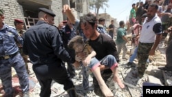 A man carries an injured child found in the rubble after an Iraqi Sukhoi jet accidentally dropped a bomb in Ni'iriya, an eastern neighborhood in Baghdad, July 6, 2015..